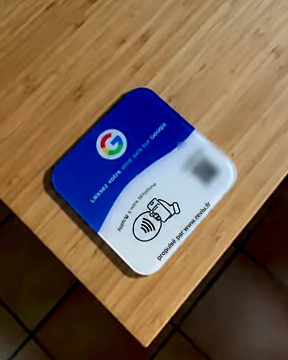 Présentoir Reviu posé à plat sur une table en bois chez un client